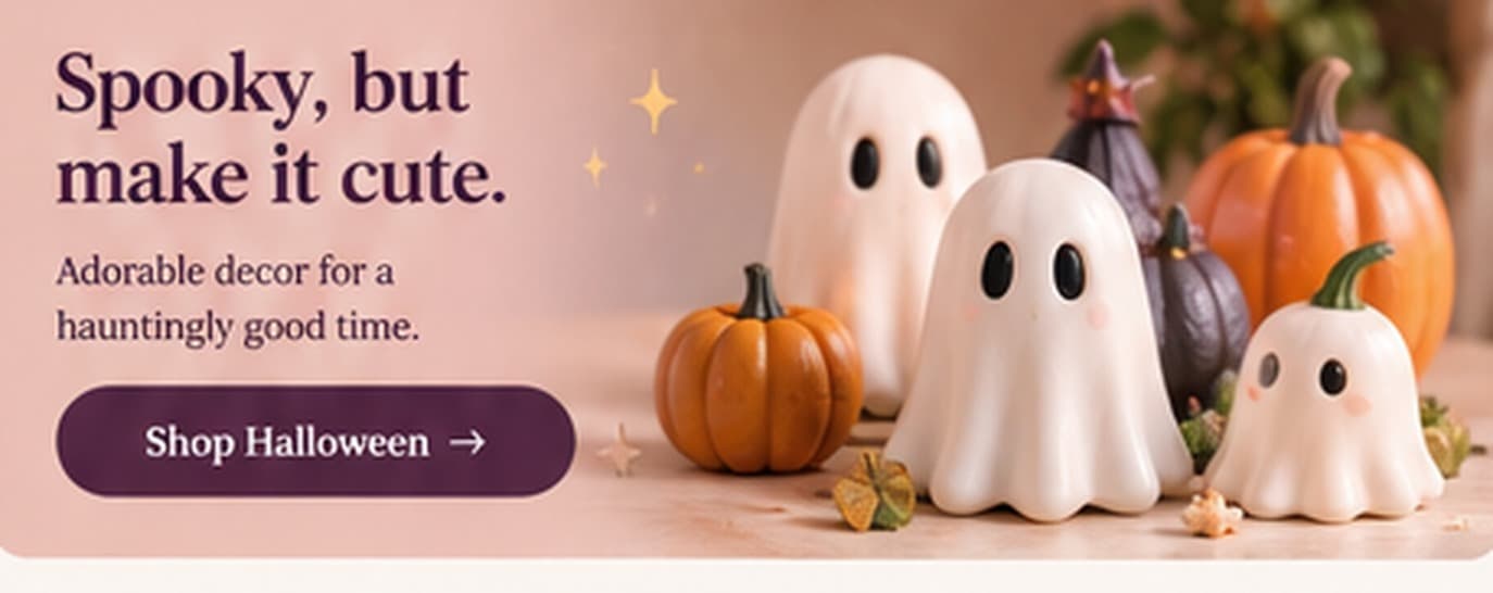 Three small 3D printed ghosts beside printed pumpkins.